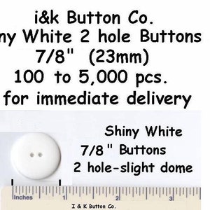 May include: Shiny white 7/8 inch (23 mm) two-hole buttons with a slight dome. The buttons are shown on a ruler for size reference. i&k Button Co. 100 to 5,000 pcs. for immediate delivery.