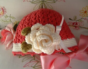 Crochet baby hat in dark pink and white wool with a rose applied. Children's fashion Idea winter. Romantic and feminine style