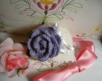 Hand crocheted hat for baby girls in white wool with a purple rose applied. Crochet romantic and feminine baby fashion