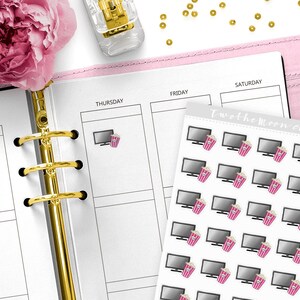 May include: A sheet of planner stickers featuring a gray television and a pink popcorn bucket. The stickers are on a white background and are placed on a pink planner. The text "Twothemoon co" is visible.
