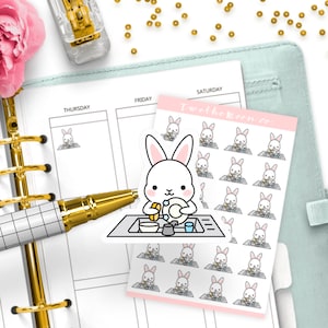 Può includere: Un foglio di adesivi per planner rosa e bianchi con un coniglio dei cartoni animati che lava i piatti. Gli adesivi dicono "Two the Moon Co."