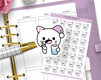 Puede incluir: Una agenda con un bolígrafo dorado, pegatinas y una flor rosa. Las pegatinas presentan un gato blanco con un gorro de dormir rosa sosteniendo una pastilla y un vaso de agua. La agenda está abierta a una semana.
