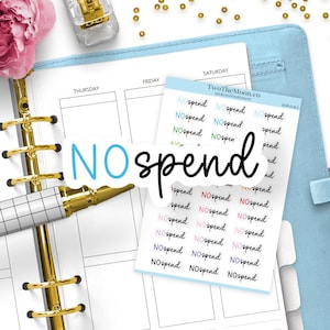 Könnte beinhalten: Ein Bogen mit Planer-Aufklebern mit dem Text NO spend in verschiedenen Farben und Schriftarten sowie ein einzelner Stanzaufkleber mit dem Text NO spend in Blau und Schwarz. Die Aufkleber liegen auf einem offenen Planer mit Goldringbindung.