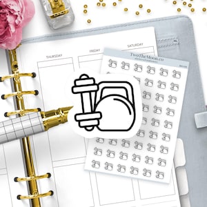May include: A sticker sheet featuring multiple small black line art icons of a dumbbell and a kettlebell. A single, larger die-cut sticker of the same dumbbell and kettlebell design is placed on top of the sheet, which is labeled TwoTheMoon.co.
