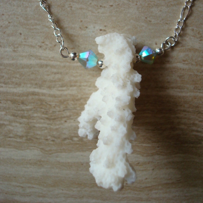 May include: A white coral pendant necklace with iridescent blue and green crystal beads on a silver chain.