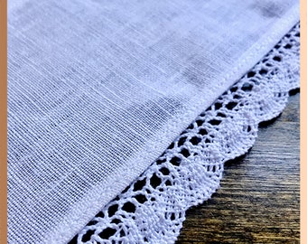 May include: White fabric with a white lace trim. The fabric is smooth and the lace is delicate.