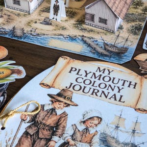 May include: A paper craft set featuring a My Plymouth Colony Journal with illustrations of two children in historical attire, a sailing ship, and a 3D diorama of a colonial settlement with paper houses and figures on a printed landscape base.