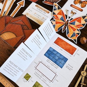 May include: An educational math worksheet featuring definitions for area, perimeter, and square units with diagrams. The page includes a wooden ruler showing 10 inches, a brass compass, a geometric butterfly cutout, and various wooden shape tiles.