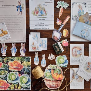 Może przedstawiać: Kolekcja wycinanek i ilustracji na papierze o tematyce Piotrusia Królika, w tym strony z opowieściami, wycinanki postaci i warzywa ogrodowe. Paleta kolorów obejmuje miękkie odcienie niebieskiego, zielonego i pomarańczowego, z widocznym tekstem z opowieści.