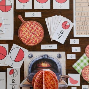 May include: A collection of educational math materials featuring printed cards with fraction diagrams, pie charts, and text labels. Included are illustrations of lattice-crust pies, a brick oven, and various numerical fraction representations on white paper.