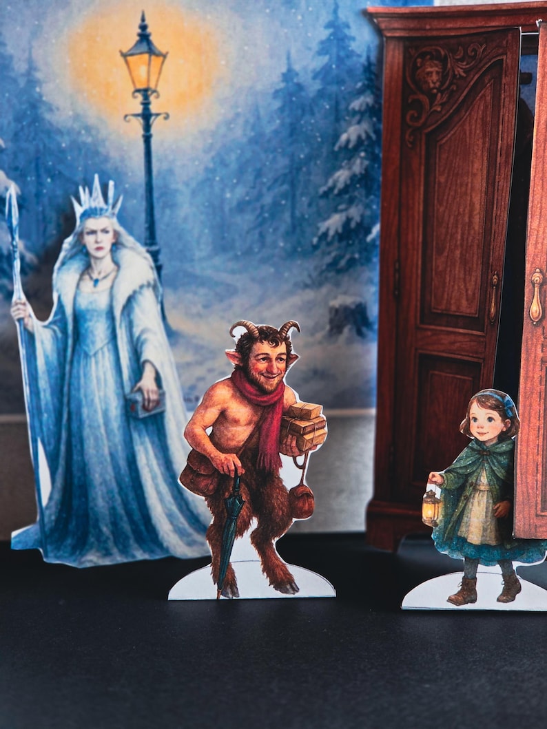 May include: A pop-up book scene featuring illustrated characters in a winter setting. The characters include a queen in a white gown, a faun with a red scarf, and a girl holding a lantern. A wardrobe and a lamppost are also visible.