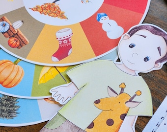 May include: A paper doll of a child wearing a green shirt with a giraffe design. The doll is holding a yellow umbrella. The background is a colorful wheel with images of the seasons.