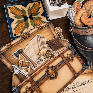 May include: A paper craft set featuring a brown trunk illustration containing cutouts of an axe, a spool of thread, a needle, a sack of grain, and a Holy Bible. Nearby are a black cauldron with food-shaped cutouts, a key, and a Mayflower Compact document.