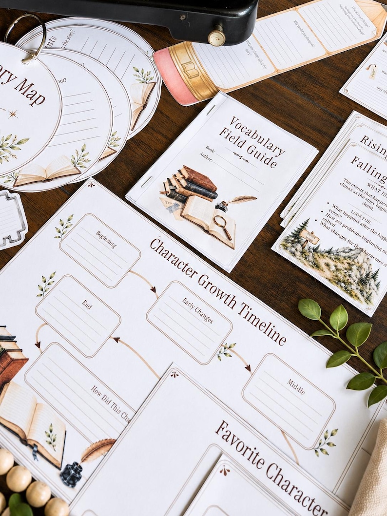 May include: A collection of printed educational worksheets for literature study, including a Character Growth Timeline, a Vocabulary Field Guide, and circular Story Map cards. The papers feature illustrations of books, quills, and inkwells with text.