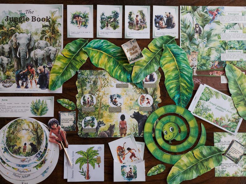 May include: A collection of illustrated items from "The Jungle Book" including a book, cards, and decorative leaves. The book cover features elephants and the title. Other cards depict scenes with animals and characters. A green snake is also present.
