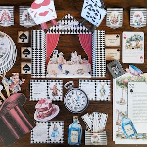 May include: A collection of Alice in Wonderland themed paper cutouts and decorations. Includes playing cards, a pocket watch, a cake, a bottle labeled "Drink Me", and a stage scene. The color palette features red, black, white, and pastel hues.