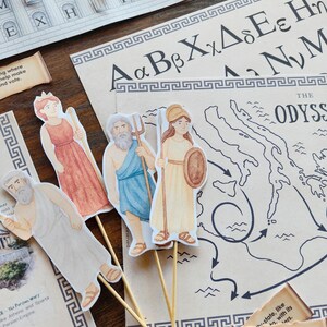May include: A collection of educational materials featuring Greek mythology and history. Includes paper cutouts of figures, a map of The Odyssey, and architectural elements. The materials are designed for learning and play.