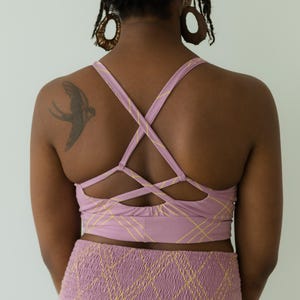 Peut inclure: Ensemble de soutien-gorge de sport et short taille haute lilas. Le soutien-gorge pr&eacute;sente un dos crois&eacute; et le short une taille smock&eacute;e. Les deux pi&egrave;ces ont un motif quadrill&eacute; jaune. L'ensemble est fait d'une mati&egrave;re douce et confortable.