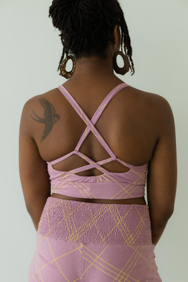 Peut inclure: Ensemble de soutien-gorge de sport et short taille haute lilas. Le soutien-gorge pr&eacute;sente un dos crois&eacute; et le short une taille smock&eacute;e. Les deux pi&egrave;ces ont un motif quadrill&eacute; jaune. L'ensemble est fait d'une mati&egrave;re douce et confortable.