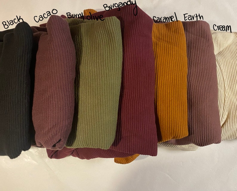 May include: A set of ten ribbed fabric swatches in various colors, including black, cacao, burnt olive, burgundy, caramel, earth, and cream.