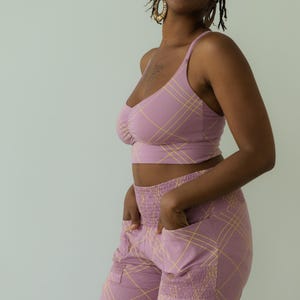 Peut inclure: Ensemble deux pi&egrave;ces mauve avec un motif &agrave; carreaux jaune. L'ensemble comprend un crop top &agrave; fines bretelles et un pantalon taille haute avec des poches. Le v&ecirc;tement est fait d'un tissu doux et confortable.