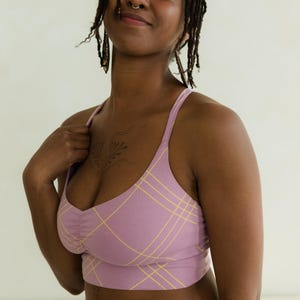 Peut inclure: Un ensemble crop top et bas lilas avec un motif &agrave; carreaux jaunes. Le haut a de fines bretelles et un d&eacute;tail fronc&eacute; &agrave; la poitrine. L'ensemble est fait d'une mati&egrave;re douce et confortable.