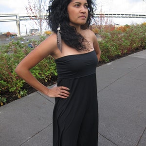 May include: A black strapless maxi dress with a fitted bodice and a flowing skirt. The garment features a simple, solid black design with a straight neckline and a long, loose-fitting silhouette that extends down to the lower legs.