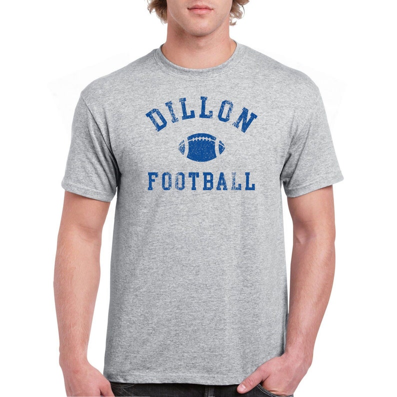 Pode incluir: Uma camiseta cinza com um gr&aacute;fico azul desbotado de uma bola de futebol e o texto "Dillon Football".