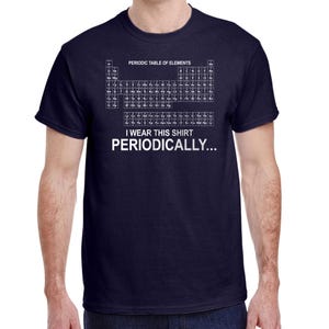 May include: Navy blue t-shirt featuring the periodic table of elements printed in white. The text "I wear this shirt periodically..." is below the table. A short-sleeved, crew neck shirt.