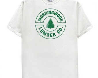 May include: White t-shirt with a green circular logo that says "Morningwood Lumber Co." and features a stylized pine tree.