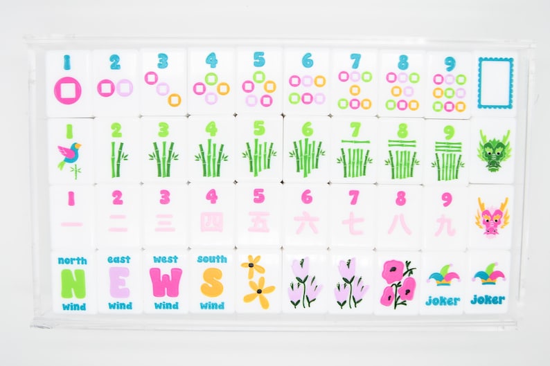 May include: A set of white Mahjong tiles with colorful symbols and numbers, including circles, bamboo stalks, and dragons. The tiles are arranged in a clear acrylic case. The bottom row features the words "NEWS" and "Joker".