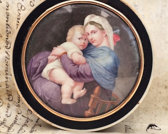 Tabaquera redonda de ébano con montura de oro de la Virgen y el Niño, según Rafael, 1820.