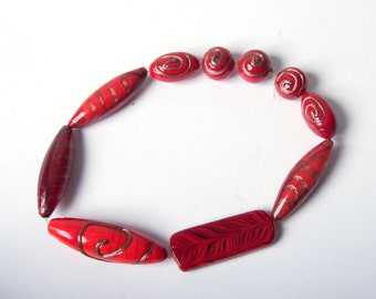 A mix of 10 red Murano glass beads with gold swirls