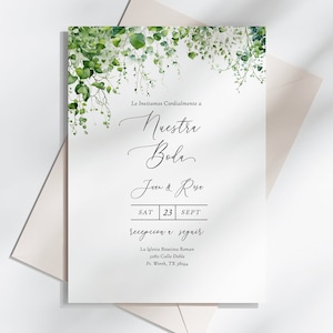 May include: A white wedding invitation with green foliage border. The text reads "Le Invitamos Cordialmente a Nuestra Boda" followed by "Juan & Rosa" and "Sat 23 Sept" and "Recepcion a Seguir". The invitation also includes the location and address.