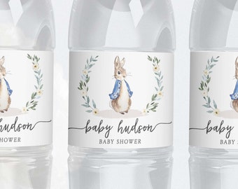 May include: Three clear plastic water bottles with labels featuring a watercolor illustration of a bunny wearing a blue jacket. The labels also include the text "baby hudson baby shower".