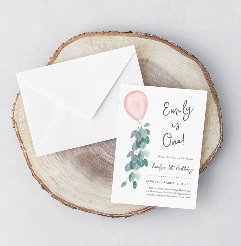 May include: A pink and green watercolor invitation for a first birthday party. The invitation features a pink balloon with green leaves and white flowers. The text on the invitation reads "Emily is One!" and includes the date and time of the party.