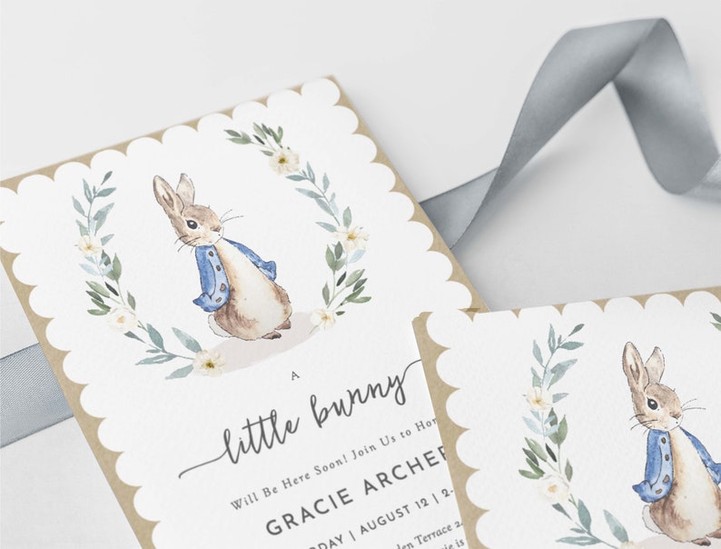 May include: A baby shower invitation with a watercolor illustration of a bunny rabbit wearing a blue jacket. The invitation reads "A little bunny Will Be Here Soon! Join Us to Honor Gracie Archer Saturday August 12 | 2-4 PM 1234 Garden Terrace"