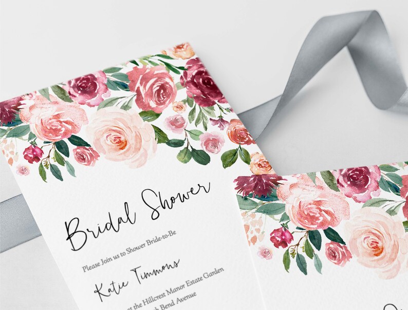 Op de afbeelding: Een bruidsdouche-uitnodiging met een aquarelbloemendesign in roze en bordeaux tinten. De tekst luidt "Bridal Shower" en "Please Join us to Shower Bride-to-Be Katie Timmons at the Hillcrest Manor Estate Garden Bend Avenue".