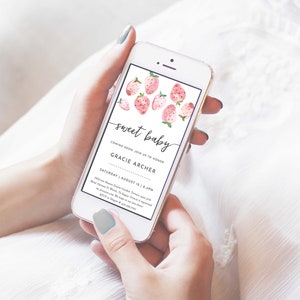 May include: A pink and white baby shower invitation on a smartphone screen. The invitation features a watercolor illustration of strawberries and the text "sweet baby" and "Gracie Archer". The date and time of the event are listed as "Saturday, August 12, 1-4 PM".