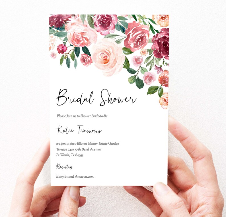 Op de afbeelding: Een witte bruiloftsdouche-uitnodiging met een bloemenontwerp in roze en bordeauxrode tinten. De tekst luidt "Bridal Shower", "Please Join us to Shower Bride-to-Be", "Katie Timmons", "2-4 pm at the Hillcrest Manor Estate Garden", "Terrace 2405 57th Bend Avenue", "Ft Worth, Tx 84953", "Registry", "Babylist and Amazon.com".