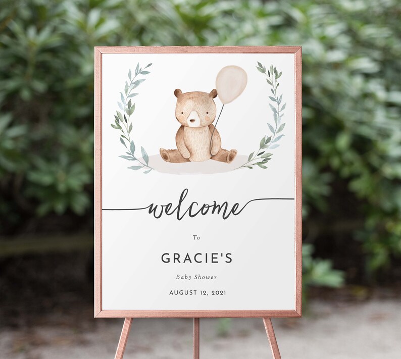 May include: Welcome sign for a baby shower with a watercolor illustration of a brown bear holding a balloon. The sign says "Welcome to Gracie's Baby Shower August 12, 2021".