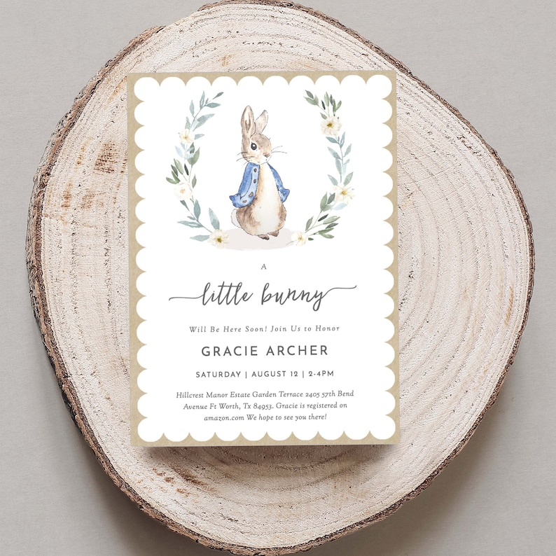May include: A baby shower invitation with a watercolor illustration of a bunny wearing a blue jacket. The invitation says "A little bunny will be here soon! Join us to honor Gracie Archer, Saturday, August 12, 2-4PM. Hillcrest Manor Estate Garden Terrace 2405 57th Bend Avenue Ft Worth, Tx 84953. Gracie is registered on amazon.com. We hope to see you there!"