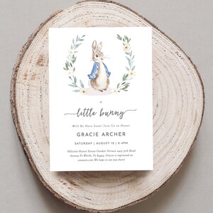 May include: A baby shower invitation with a watercolor illustration of a bunny rabbit wearing a blue jacket. The invitation reads "A little bunny Will Be Here Soon! Join Us to Honor Gracie Archer Saturday August 12 2-4PM Hillcrest Manor Estate Garden Terrace 2405 37th Bend Avenue Ft Worth, Tx 84953. Gracie is registered on amazon.com We hope to see you there!"