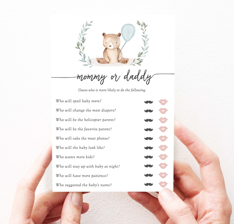Puede incluir: Tarjeta de juego para baby shower con un oso de peluche sosteniendo un globo azul y el texto "mam&aacute; o pap&aacute;". La tarjeta incluye preguntas sobre los padres, con iconos de bigote y labios.