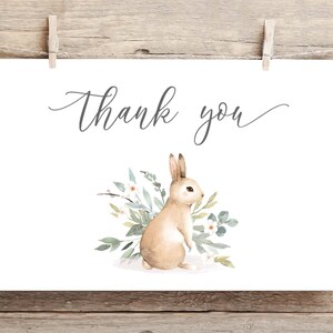 May include: A white card with the text "Thank you" in gray script. A watercolor illustration of a brown rabbit with white flowers and green leaves.