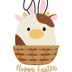 Könnte beinhalten: Eine braune und weiße Kuh mit Hasenohren befindet sich in einem braunen Weidenkorb. Der Text "Hoppy Easter" befindet sich unter dem Korb.