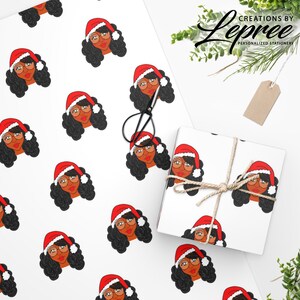 May include: White wrapping paper and a wrapped gift box featuring a repeating pattern of a woman wearing a Santa hat and glasses. The gift box is tied with twine. The image also includes a pair of scissors and a tag.