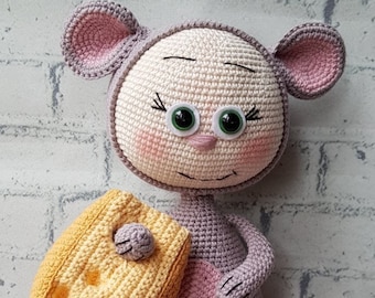 Hand crocheted doll in a mouse suit with a piece of cheese