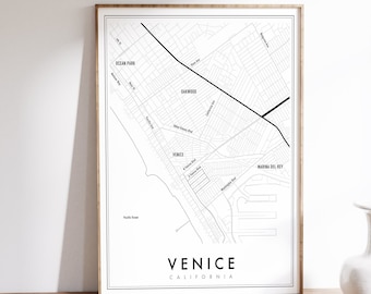 May include: A black and white map print of Venice, California. The map shows the streets and neighborhoods of Venice, including Ocean Park, Oakwood, and Marina del Rey. The text "Venice, California" is printed at the bottom of the map.