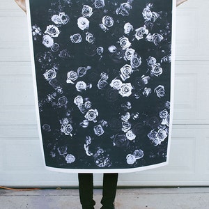 May include: A black and white photograph of a floral pattern featuring many roses. The roses are arranged in a random pattern and appear to be in bloom. The background is a dark, almost black, color.